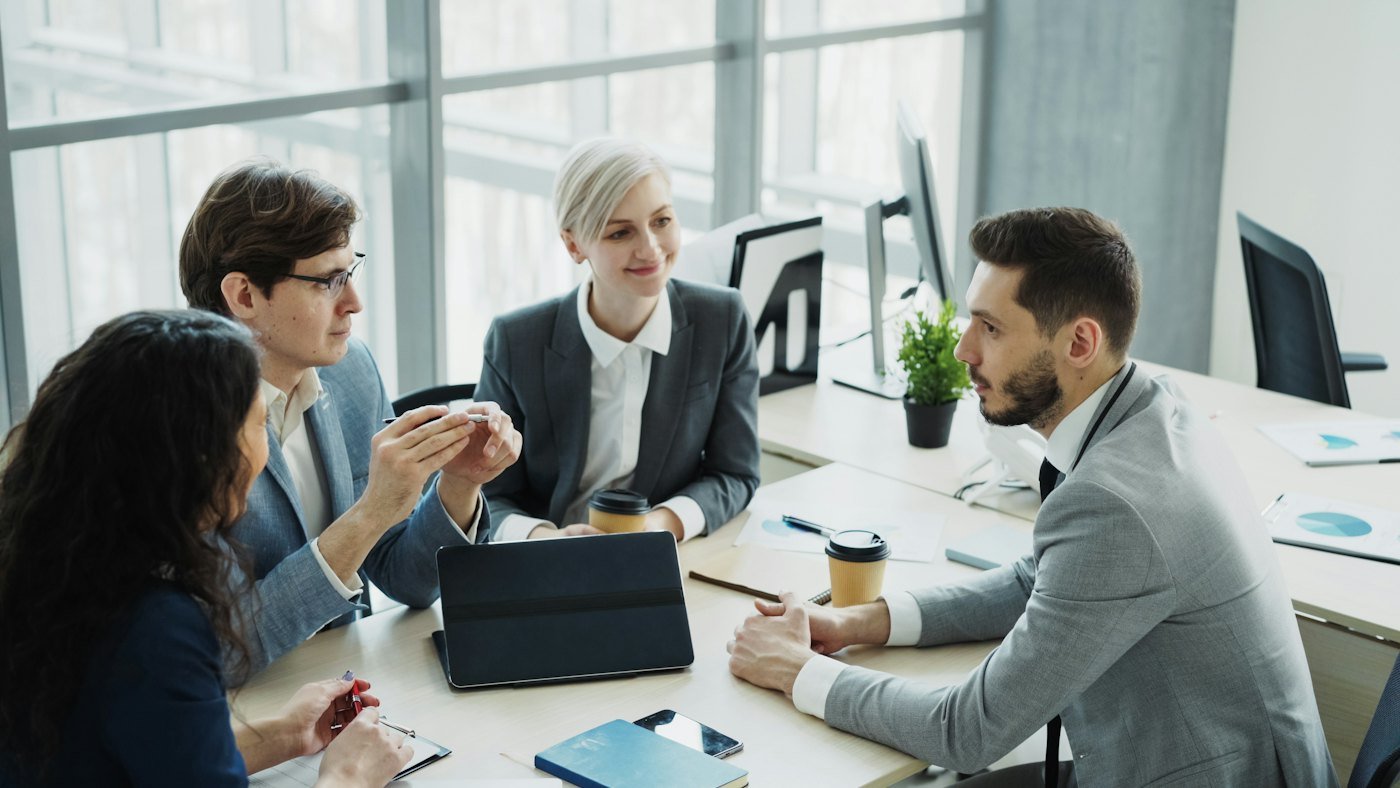 A hiring panel reviewing applications together around a meeting table